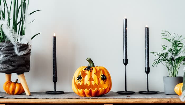 Black candles lit with a pumpkin