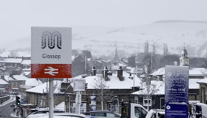 Glossop train station sign covered in snow