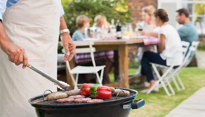 man cooking food on a bbq for his fun family bbq