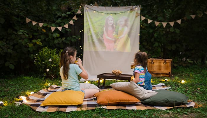 Children watching a film outdoors