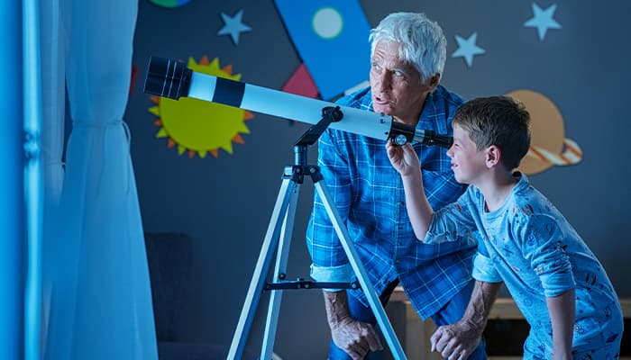 Child and grandparent looking through a telescope